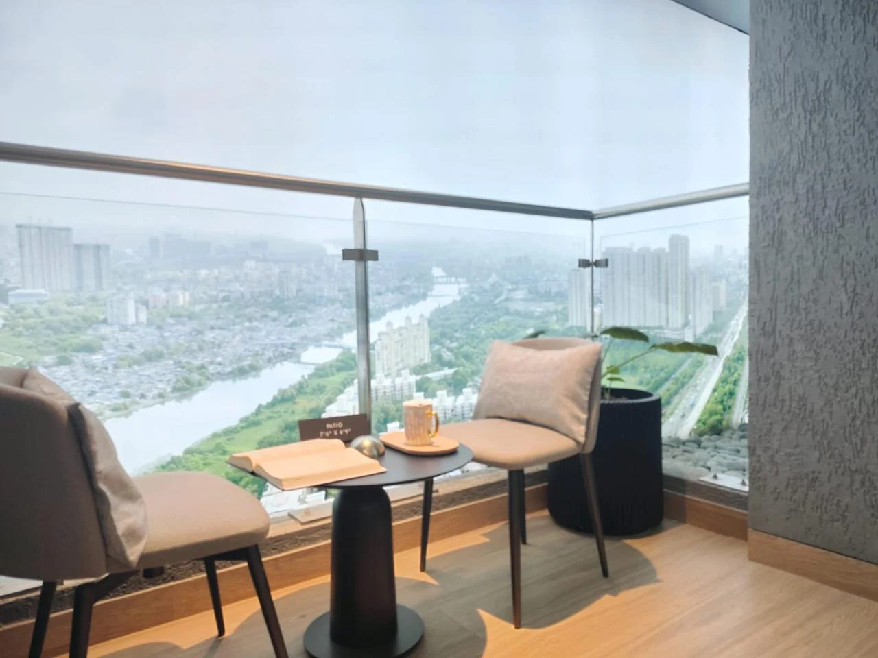 Urbania balcony with two chairs, a table and glass railing